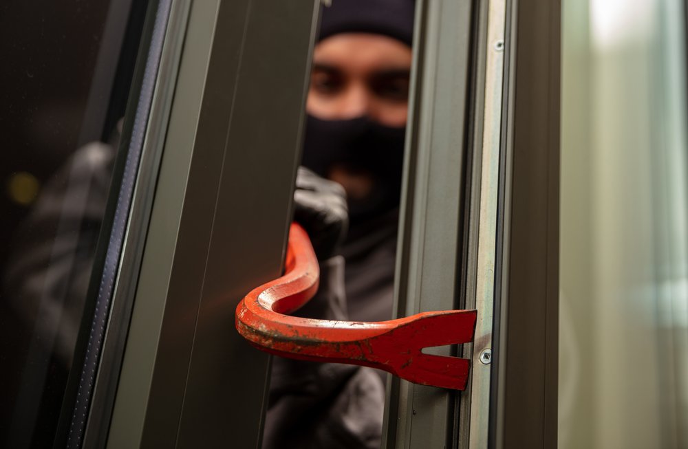 Thief holding a crowbar to break in